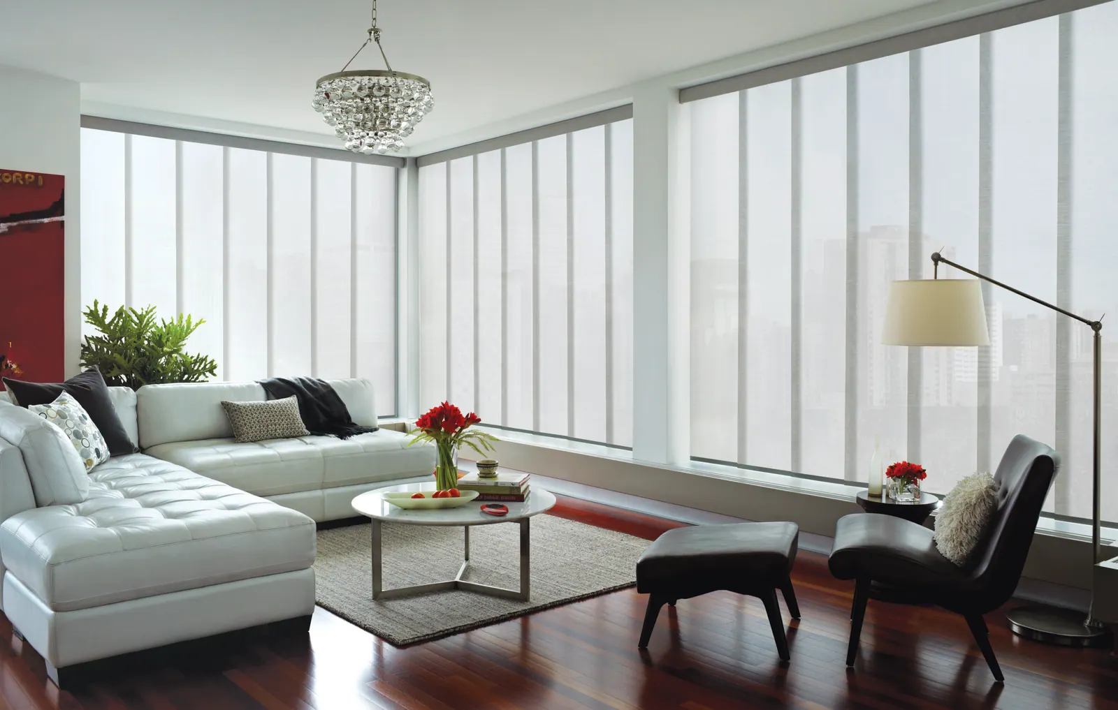 Motorized shades on high living room windows above a seating area