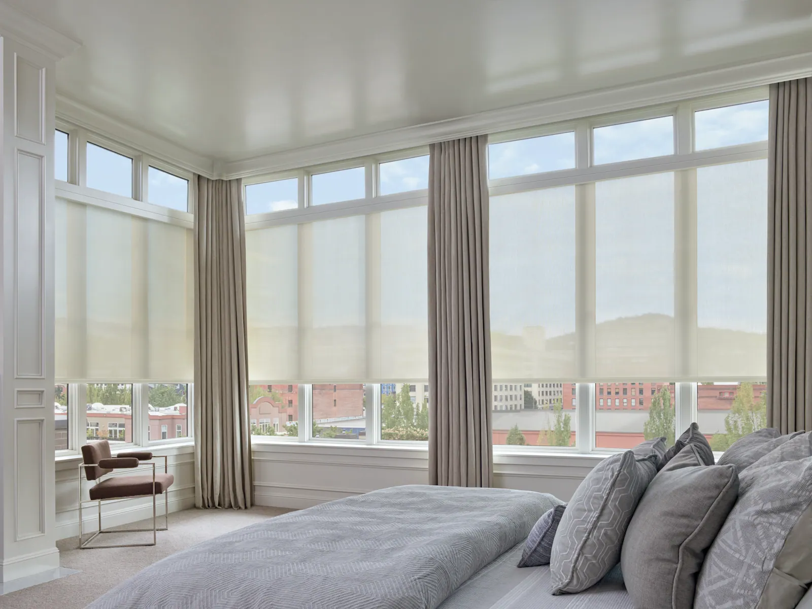 Solar screen shades cutting glare in a bedroom while keeping the view