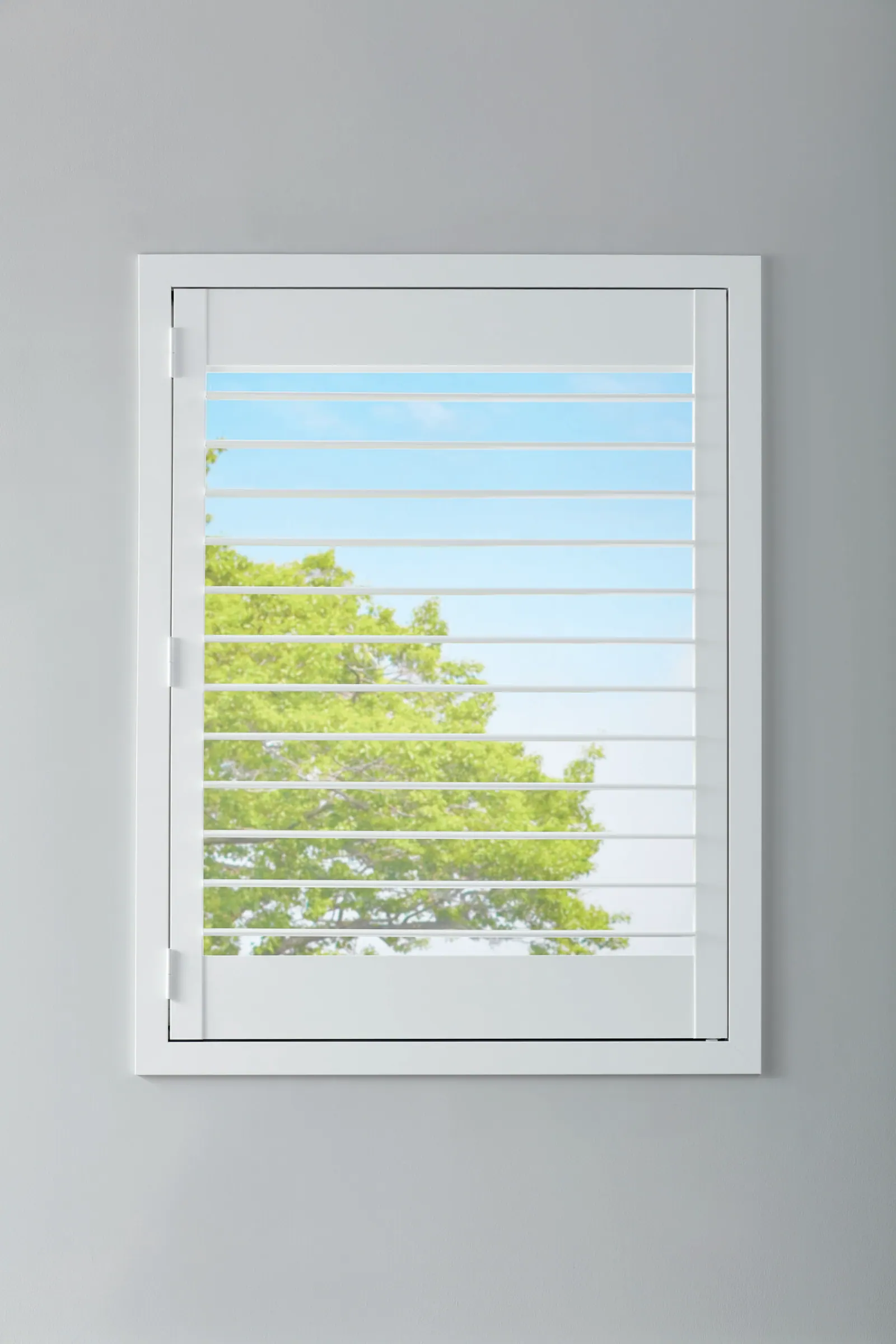 Composite shutters with a hidden tilt rail against a grey wall